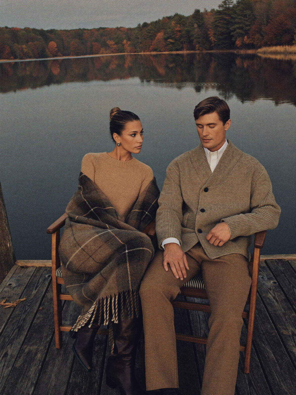 Couple in knitwear on a lake dock at dusk